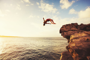 48837078 - cliff jumping into the ocean at sunset, summer fun lifestyle